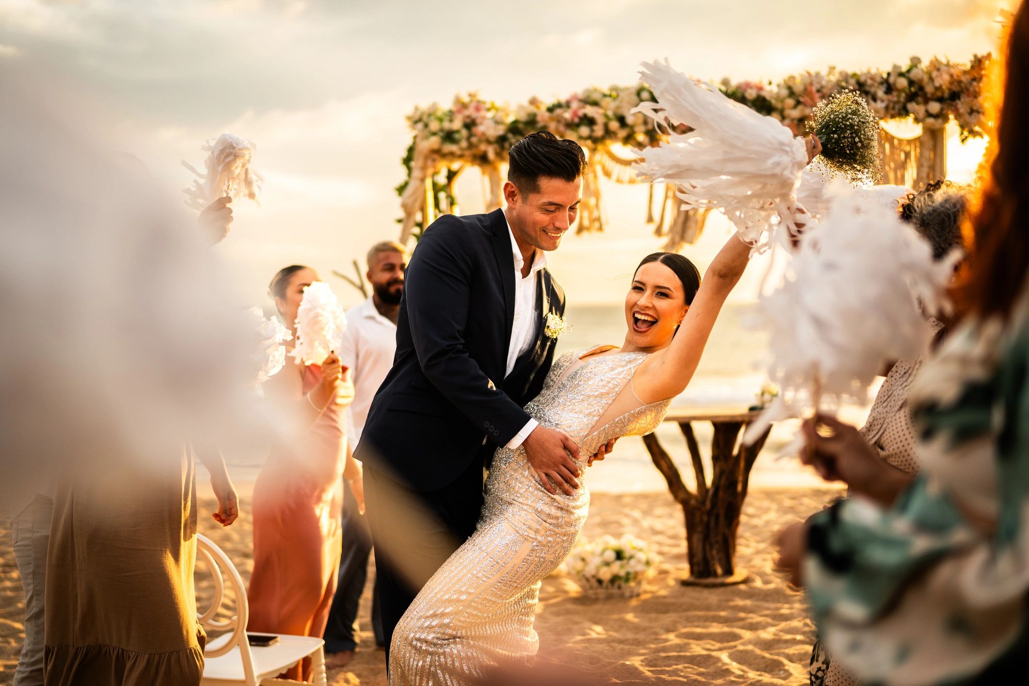 Newlyweds celebrating with guests at a beach wedding